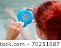 Woman in a hot tub bath checking the level of cleaning products 70251687