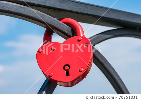 Lovers hang the lock on the railing of the bridge after the wedding Lovers hang the lock on the railing of the bridge after the wedding 70251831