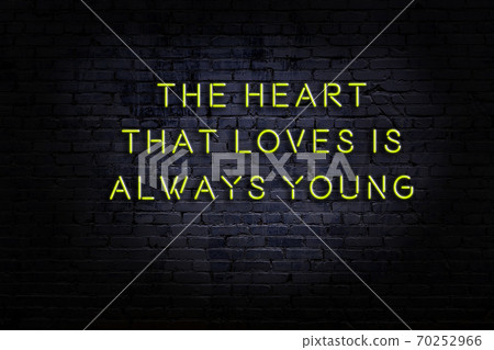 Wise quote. Neon inscription against brick wall Wise quote. Neon inscription against brick wall 70252966