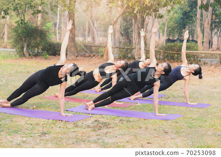 Group of asian women doing yoga beside the lake in outdoor park. 70253098