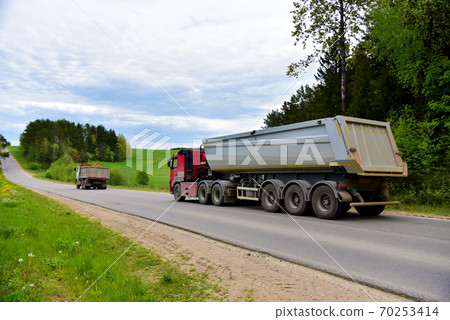Truck with tipper semi trailer transported sand from the quarry on driving along highway.  70253414