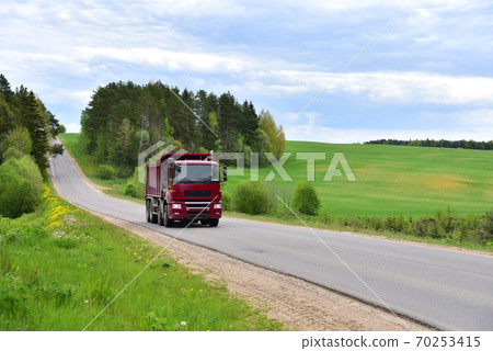 Tipper Dump Truck transported sand from the quarry on driving along highway. Tipper Dump Truck transported sand from the quarry on driving along highway. 70253415