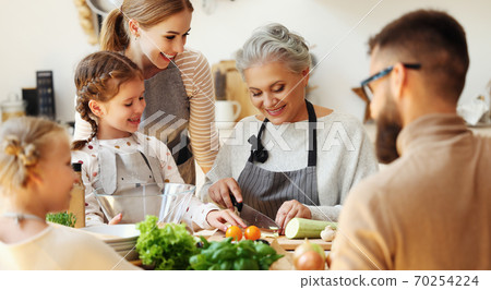 Happy family preparing healthy food in home kitchen. Happy family preparing healthy food in home kitchen. 70254224