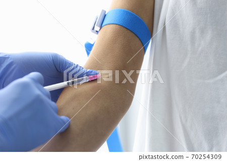 Doctor injects the patient into vein closeup 70254309