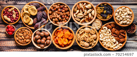 Various Nuts and dried fruits in wooden bowls. Various Nuts and dried fruits in wooden bowls. 70254697