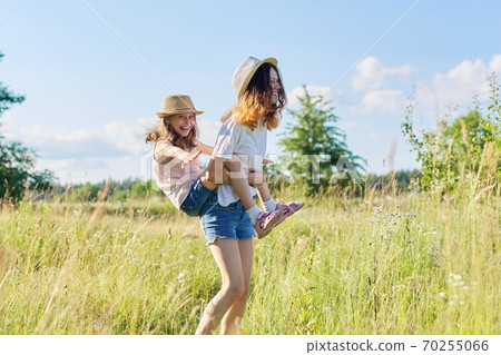 Happy laughing children playing in meadow, two sister girls having fun in nature Happy laughing children playing in meadow, two sister girls having fun in nature 70255066