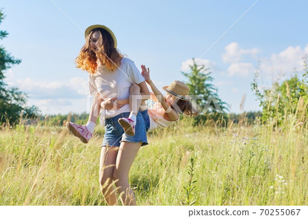 Happy children two girls sisters laughing and having fun in meadow Happy children two girls sisters laughing and having fun in meadow 70255067