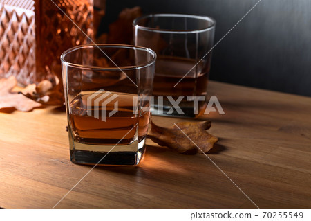 Whiskey on a old wooden table. Whiskey on a old wooden table. 70255549