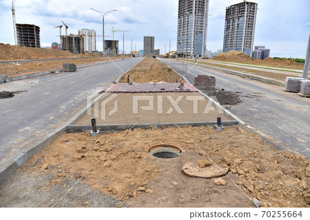 Laying paving slabs and borders at construction site.  70255664