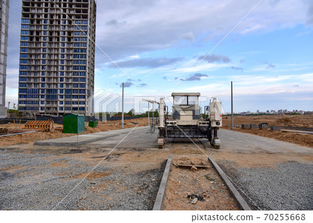 Slipform paver machine on road work at construction site. Highway concrete paving in the new quarter Slipform paver machine on road work at construction site. Highway concrete paving in the new quarter 70255668
