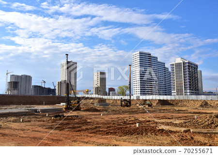Construction site with machinery for deep foundation piling. Vibrating hydraulic hammer Construction site with machinery for deep foundation piling. Vibrating hydraulic hammer 70255671
