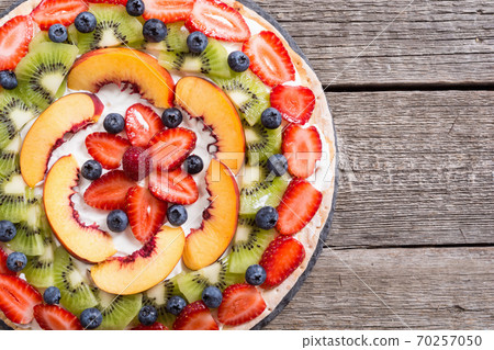 Fruit pizza with fruit and berries . 70257050