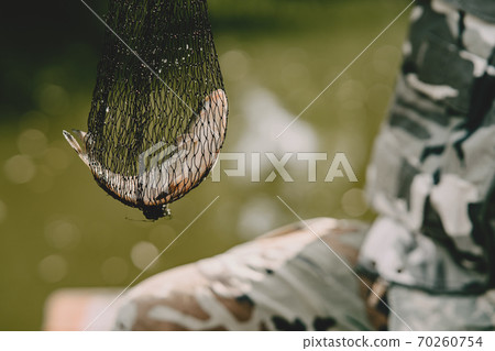 Man fishing and holds the angling rod 70260754
