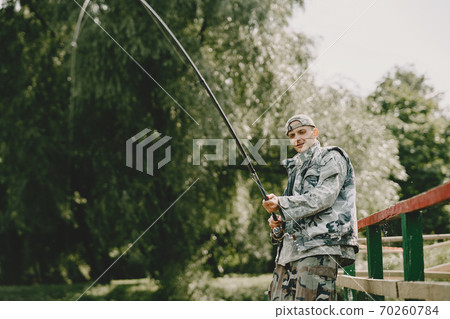Man fishing and holds the angling rod 70260784