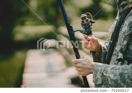 Man fishing and holds the angling rod 70260817