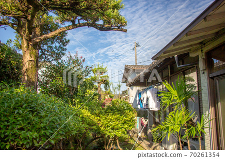 Laundry dried under the eaves of an old folk house Blue sky and laundry of an old folk house Laundry dried under the eaves of an old folk house Blue sky and laundry of an old folk house 70261354