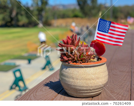 Patriotic flower pot with American flags and golfer on the background. Patriotic flower pot with American flags and golfer on the background. 70261409