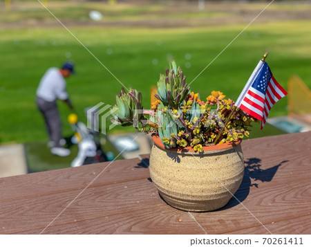 Patriotic flower pot with American flags and golfer on the background. 70261411
