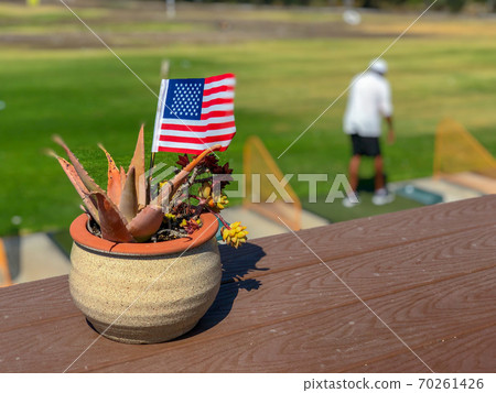 Patriotic flower pot with American flags and golfer on the background. 70261426