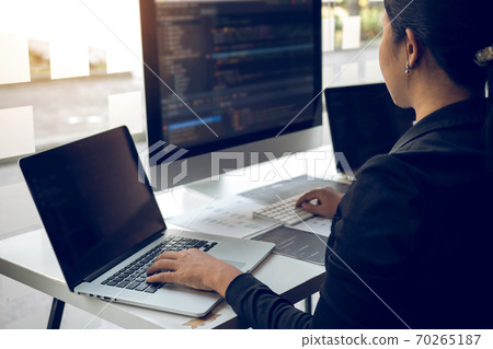 Developing programming and coding technologies working in a software engineers developing applications together in office. Developing programming and coding technologies working in a software engineers developing applications together in office. 70265187