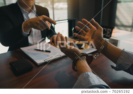 Police officers pointed to the handcuffs of offenders and talked about the offense of corruption charges. Police officers pointed to the handcuffs of offenders and talked about the offense of corruption charges. 70265192