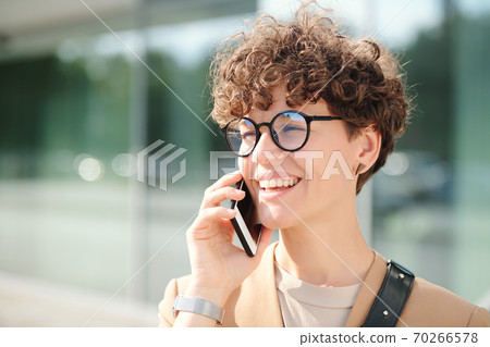 Happy young elegant businesswoman with smartphone by ear consulting client 70266578