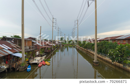 Utility poles tower and cable wires and Chao Phraya River with reflection of lake at sunset in Bangkok, Thailand in energy electric technology and industry concept. 70266871