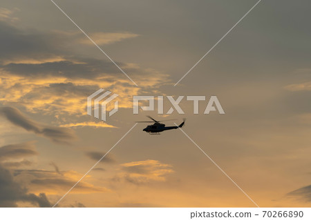 Close up of transport helicopter or military aircraft flying isolated on sunset sky 70266890