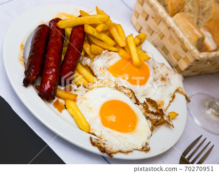 Huevos con chistorra. Scrambled eggs with sausage and potatoes. Spanish cuisine 70270951