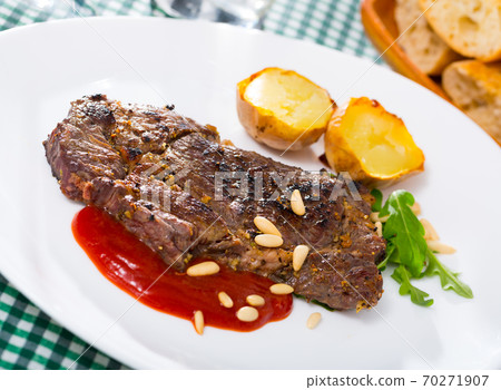 Well done roasted veal steak with ketchup, pine nuts 70271907