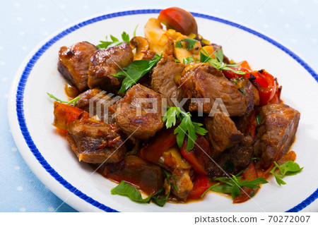 Delicious fried pork with button mushroom, peppers and greens 70272007