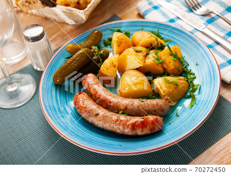 Sausages with potatoes and pickled cucumbers Sausages with potatoes and pickled cucumbers 70272450