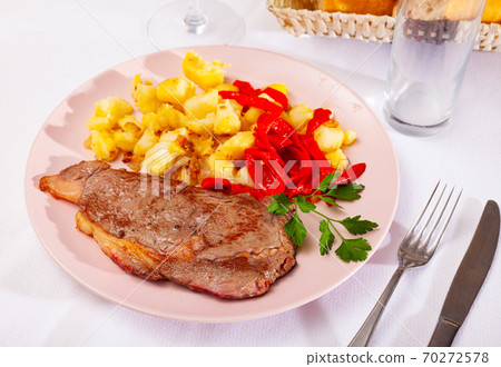 Veal steak with fried potato and pepper 70272578