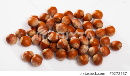Heap of raw hazelnuts on white Heap of raw hazelnuts on white 70272587