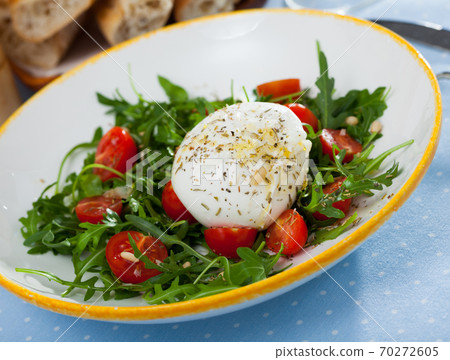 Salad with burrata italian cheese, cherry tomatoes and arugula green leaf Salad with burrata italian cheese, cherry tomatoes and arugula green leaf 70272605