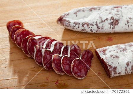 Spanish sausage fuet on a wooden table, closeup Spanish sausage fuet on a wooden table, closeup 70272861