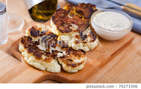 Grilled cauliflower on wooden cutting board Grilled cauliflower on wooden cutting board 70273306