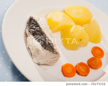 Pollock prepared on steam, served with boiled potatoes and carrots 70273316