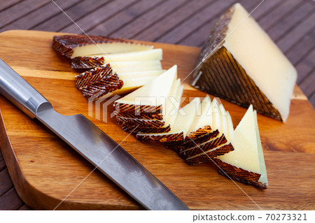 Slices of semi-hard spanish sheep cheese on desk Slices of semi-hard spanish sheep cheese on desk 70273321