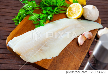 Raw atlantic cod fillet on wooden table 70273322