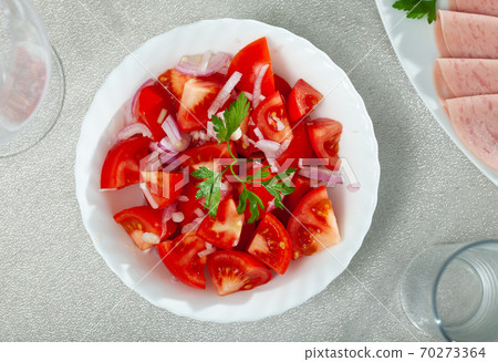 Fresh salad with tomatoes and chopped onion 70273364