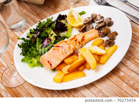 Grilled salmon steak with potato and mushrooms 70273459
