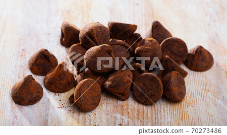 Chocolate truffles on wooden surface Chocolate truffles on wooden surface 70273486