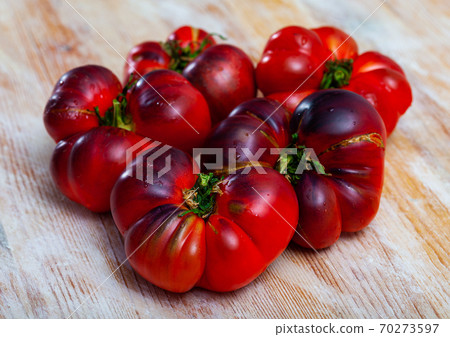Many red blue tomatoes on wooden surface Many red blue tomatoes on wooden surface 70273597