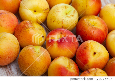 Pile of fresh ripe apricots on wooden surface Pile of fresh ripe apricots on wooden surface 70273602