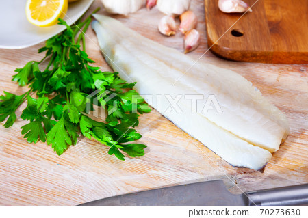 Raw atlantic cod fillet on wooden table 70273630