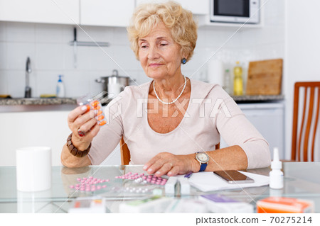 Woman among a lot of medicines 70275214