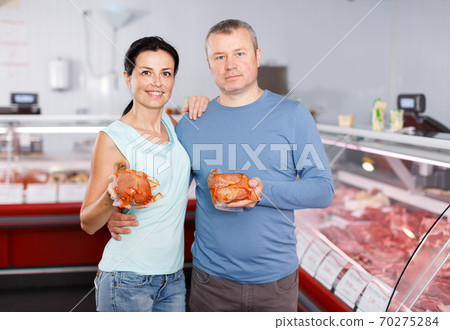 Positive couple customers posing with meat Positive couple customers posing with meat 70275284