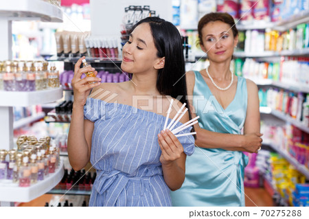 Women customers choosing perfume in cosmetic shop 70275288