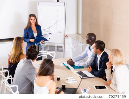 Woman making presentation on staff meeting Woman making presentation on staff meeting 70275469
